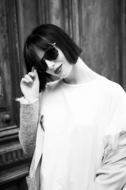 Şık, kısa, esmer saçlı bir kadın.