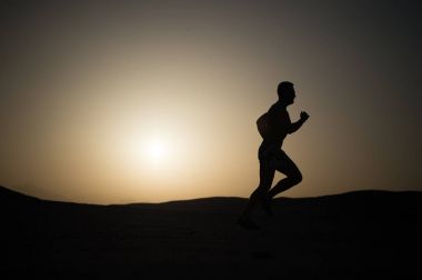 adam siluet günbatımı gökyüzüne çalıştıran