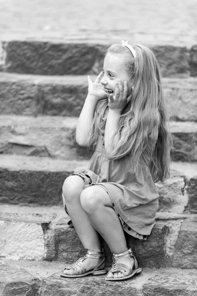 Маленькая счастливая девочка в голубом платье на красочной лестнице — стоковое фото