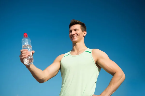 Hombre feliz con botella de agua en manos musculosas — Foto de Stock