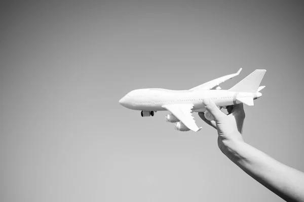 White toy plane in female hand on sunny blue sky — Stock Photo, Image