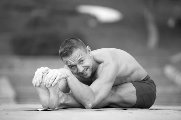 Atletisk man som gör yoga asanas i parken — Stockfoto
