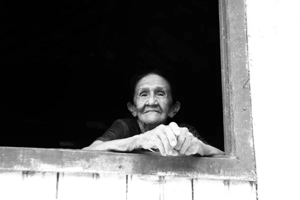 Smiling old woman in window — Stock Photo, Image