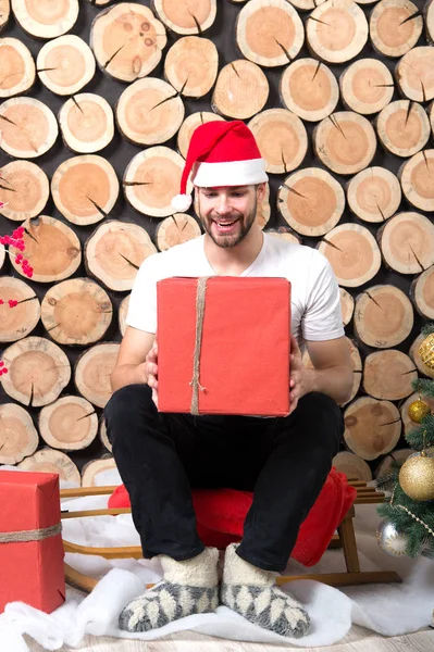 Santa mannen med rutan sitta på trä logg bakgrund — Stockfoto