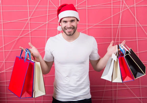 Weihnachtsmann-Shopper mit Papiertüten auf rosa Hintergrund — Stockfoto