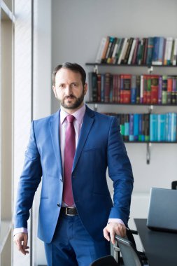 Mavi takım elbiseli sakallı adam.