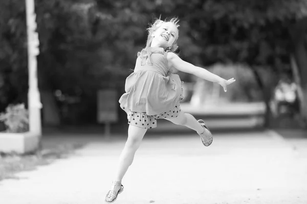Mavi elbiseli atlama yüz gülümseyen kız küçük bebek — Stok fotoğraf