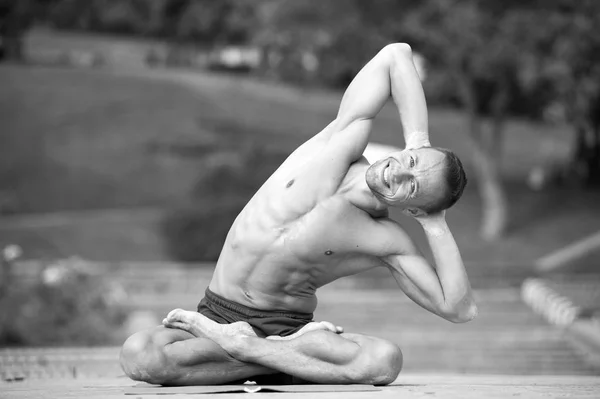 Hombre atlético haciendo asanas de yoga en el parque — Foto de Stock