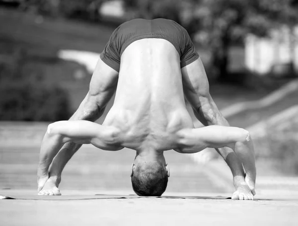 Atletický muž dělá jógu asanas v parku — Stock fotografie