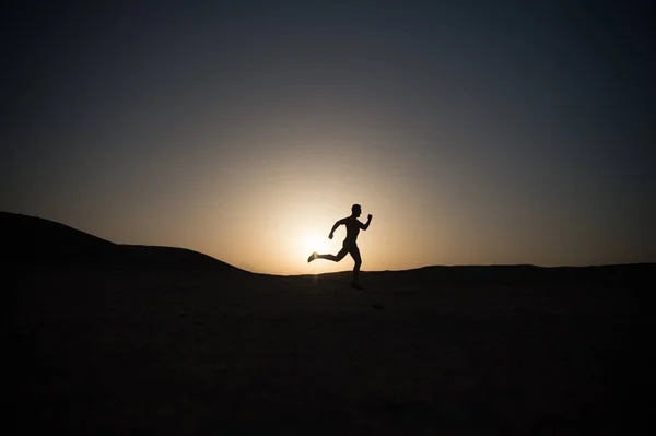 Correndo silhueta homem no céu por do sol — Fotografia de Stock