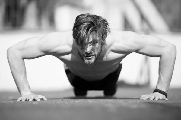 Hombre musculoso haciendo flexiones, atleta masculino haciendo ejercicio push up —  Fotos de Stock