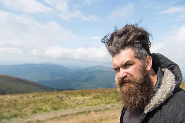 Hombre hipster con pelo de barba larga en el paisaje de montaña — Foto de Stock
