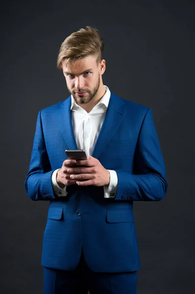 Homme avec un visage sérieux en tenue formelle avec téléphone mobile — Photo