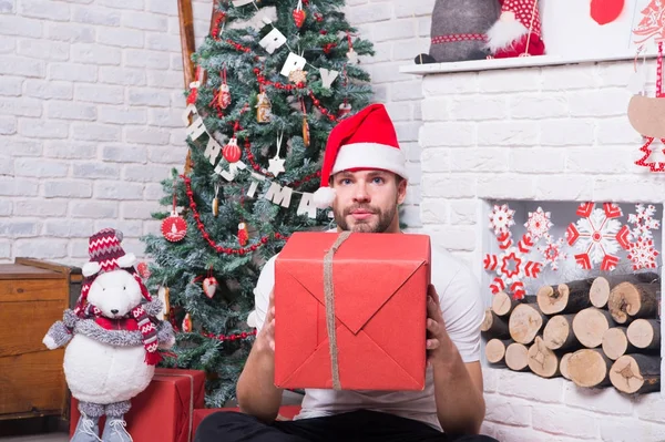 Macho drží krabičce s hračka medvěd na vánoční strom — Stock fotografie