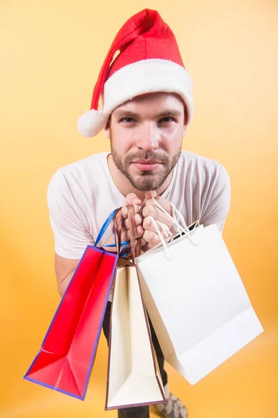 Mann mit Weihnachtsmütze und Papiertaschen — Stockfoto