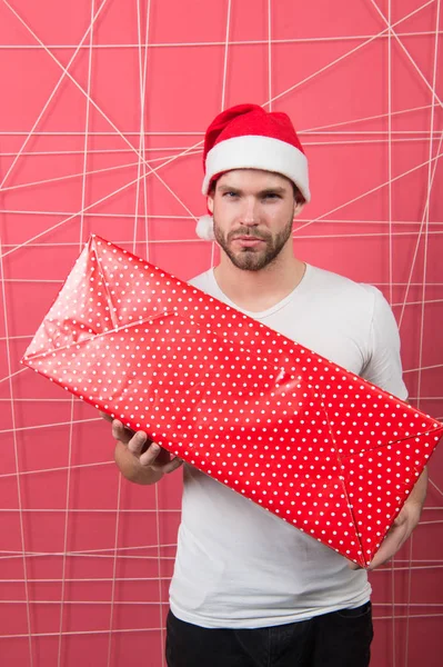 Uomo in cappello di Babbo Natale con scatola lunga su sfondo rosa — Foto Stock