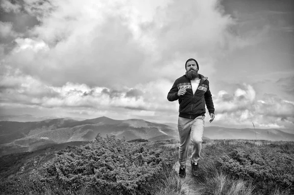 Hipster athlete, bearded man run on mountain landscape