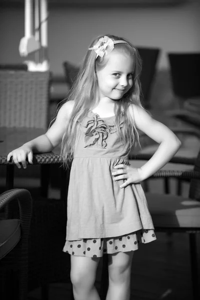 小微笑宝贝女孩的咖啡馆桌子旁边的蓝色礼服 — 图库照片