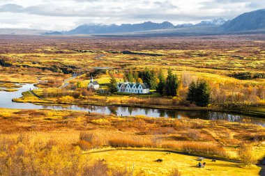 Nehir, kilise, ile kırsal dağ manzarası İzlanda'daki evler
