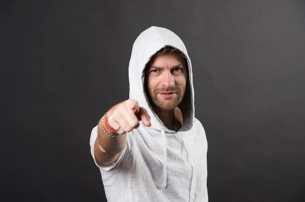 Man in hood point finger on grey background