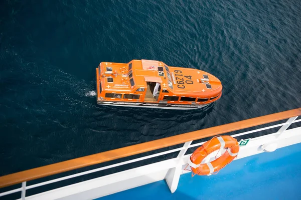 Lifeboat or orange boat on blue sea water, top view — Stock Photo, Image