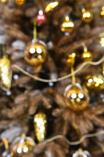 Pohon Natal dengan bola emas, kerucut, karangan bunga dengan latar belakang kabur — Stok Foto