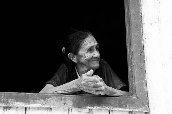 Glimlachende oude vrouw in het raam — Stockfoto