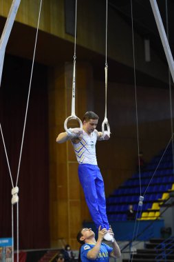 Erkek jimnastikçi sabit jimnastik halkaları gerçekleştirme