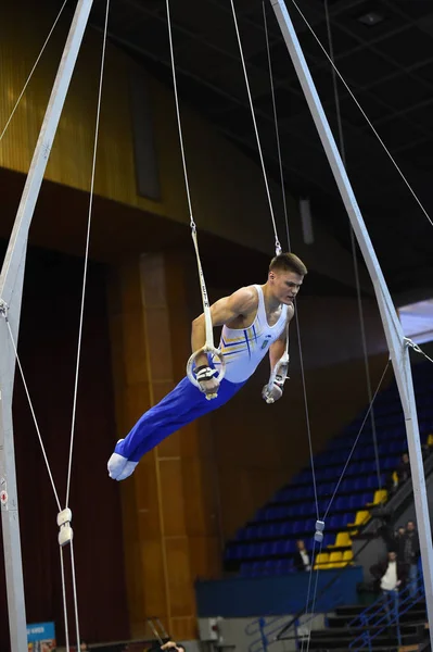 Αρσενικό gymnast εκτελεί την εν στάσει Γυμναστικά δαχτυλίδια — Φωτογραφία Αρχείου