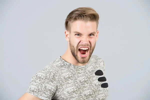 Hombre gritar enojado en camiseta sobre fondo gris — Foto de Stock