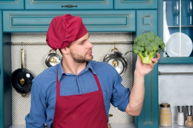 Önlük tutun yeşil brokoli kırmızı Şef şapkalı adamı