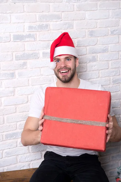 Macho in kerst hoed glimlach met huidige verpakte — Stockfoto