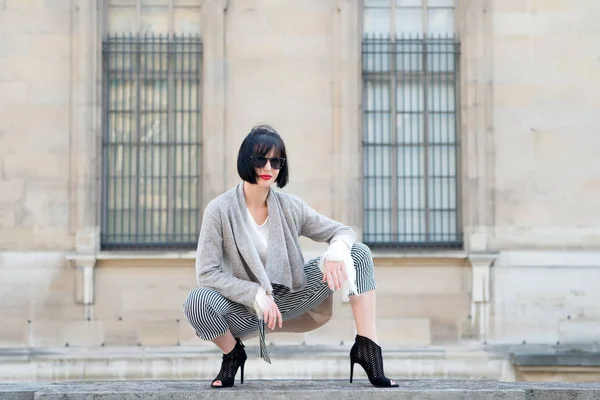 Chica sentarse en valla de piedra en la fachada de la casa en París, Francia — Foto de Stock