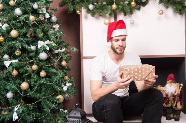 Macho i röd mössa med inslagna lådor vid spisen — Stockfoto