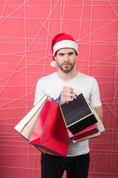 ピンクの背景に買い物袋を持つ男サンタ — ストック写真
