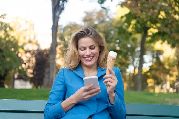 Woman smile with mobile phone ice cream in paris, france