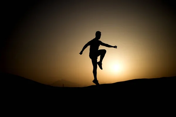 Sportovec s svalnaté tělo v soumraku — Stock fotografie