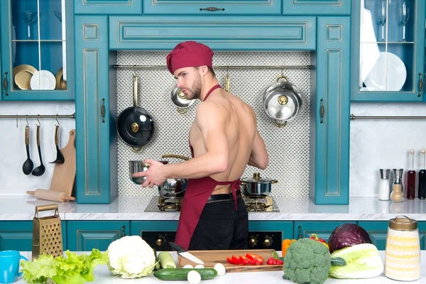 Chlap kuchař klobouk, zástěra kuchař v kuchyni — Stock fotografie