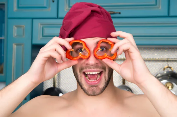 Щасливий чоловік тримає шматочки перцю перед очима, як окуляри — стокове фото