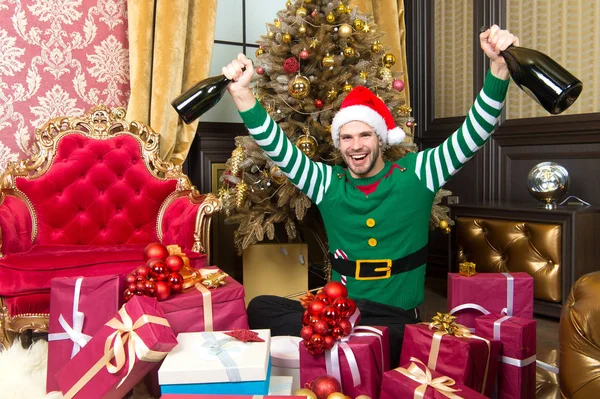 Homem em Papai Noel sorriso com garrafas de champanhe — Fotografia de Stock