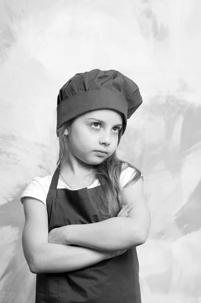 Chef menina pequena com rosto sério no chapéu e avental — Fotografia de Stock