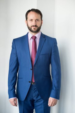 Mavi takım elbiseli sakallı adam.