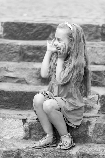 Small happy baby girl in blue dress on colorful stairs — Stock Photo, Image