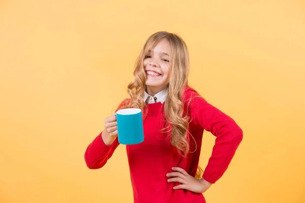 Дівчина з довгим світлим волоссям у червоному светрі тримає кухоль — стокове фото