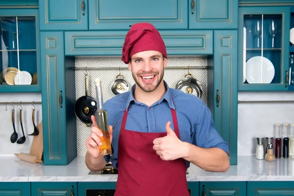 Hombre feliz chef mostrar pulgares hacia arriba con botella de aceite de oliva — Foto de Stock
