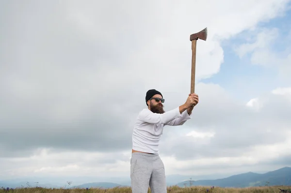 Hombre barbudo leñador en gafas de sol, sombrero levantar hacha —  Fotos de Stock