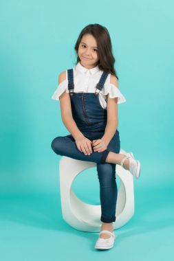 Kot pantolonlu kız mankeni sandalyeye oturur.