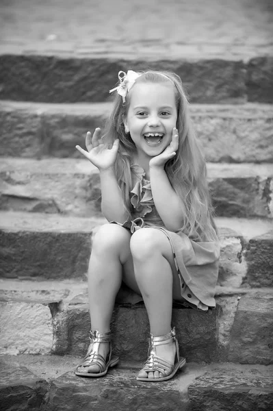 Small happy baby girl in blue dress on colorful stairs — Stock Photo, Image