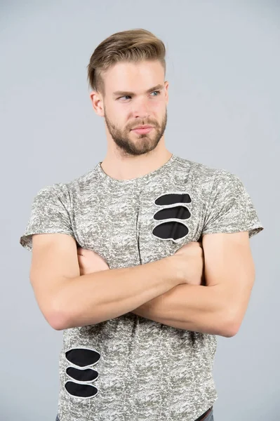 Mannen i tshirt med knäppta händer på grå bakgrund — Stockfoto