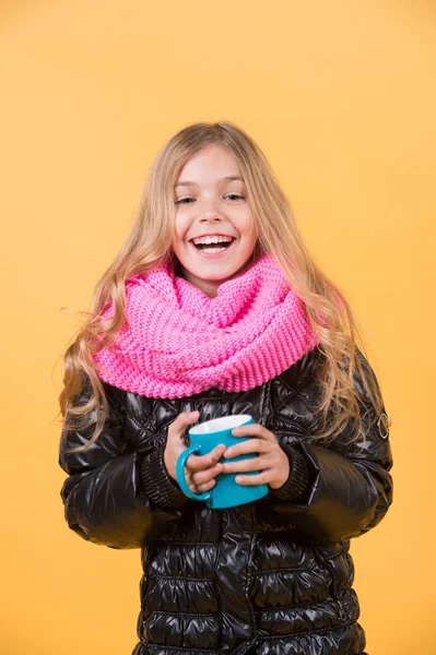 Девушка с синей чашкой улыбки на оранжевом фоне — стоковое фото